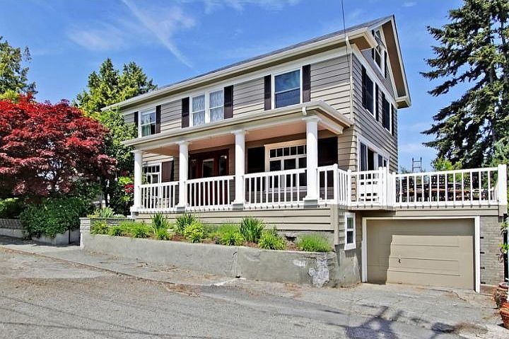 Front of home w/ attached garage and wrap around deck facing Lake Washington