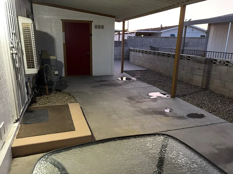 The red door is the attached shed. There is also a water softener you'll find out here.