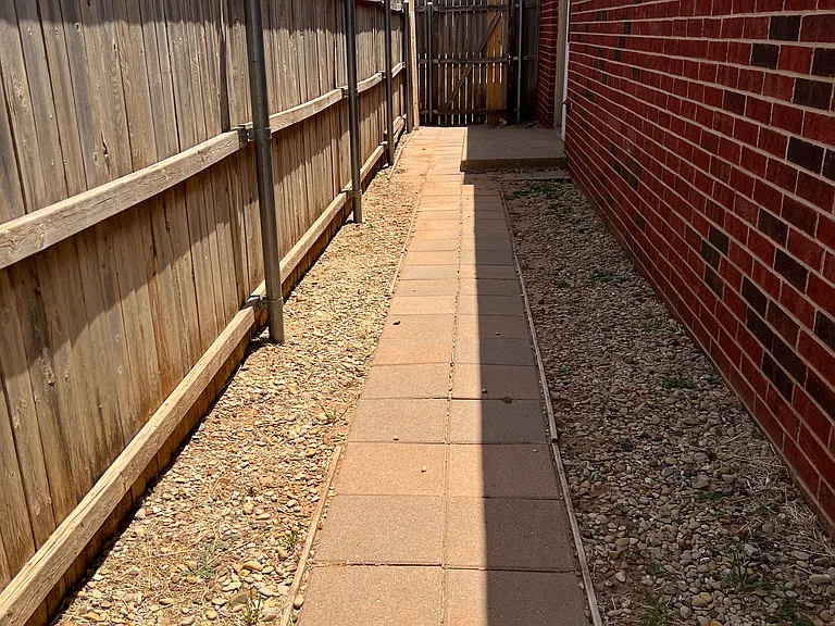 This duplex has a paved walkway to the back yard.