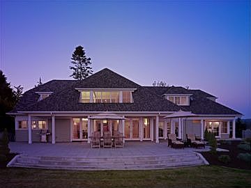 Back of home with large patio area and multiple french doors!
