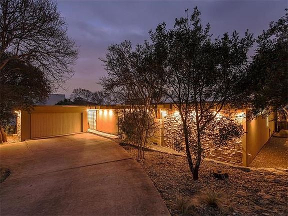 Twilight out front, with sweeping circle drive for 8-10 cars parked in driveway for parties. 2-car garage with storage/tool room.