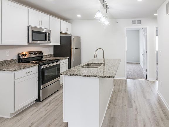 White cabinets. Island features overhang for stools