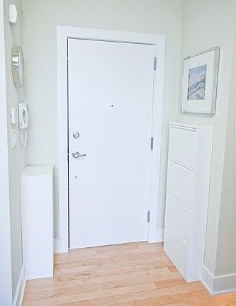 Penthouse unit’s front door with custom installed storage cabinets.