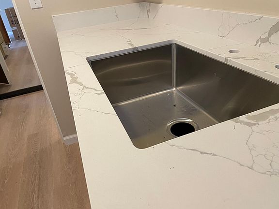New quartz countertops, new sink, and new stainless steel appliances