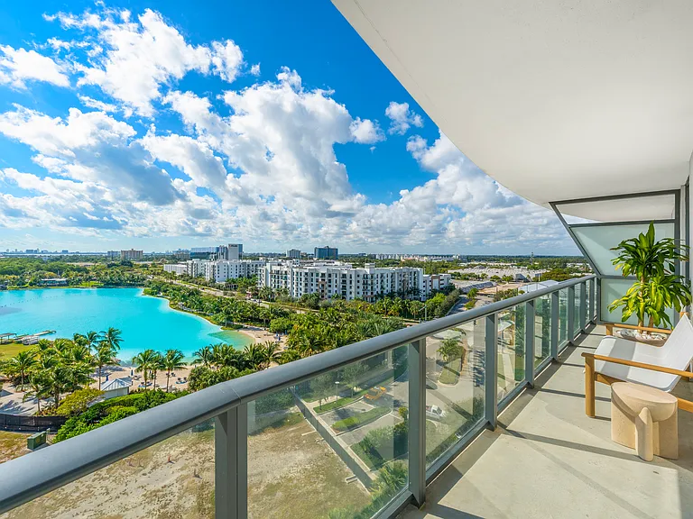 An expansive private balcony offers panoramic views of the Laguna Sole and Oleta River State Park