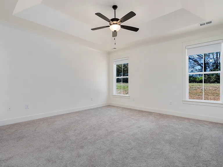 A private main suite is nestled at the back of the home featuring trey ceiling and a large walk-in closet. The closet is designed custom by Closet Pro.