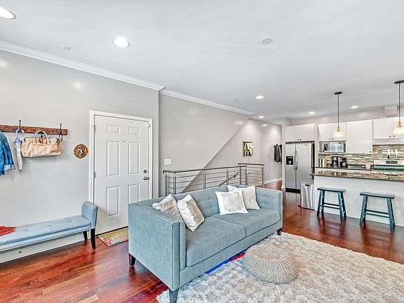 Front door, open kitchen and living room. Stairs to lower level, hallway to half bath and Master bedroom.
