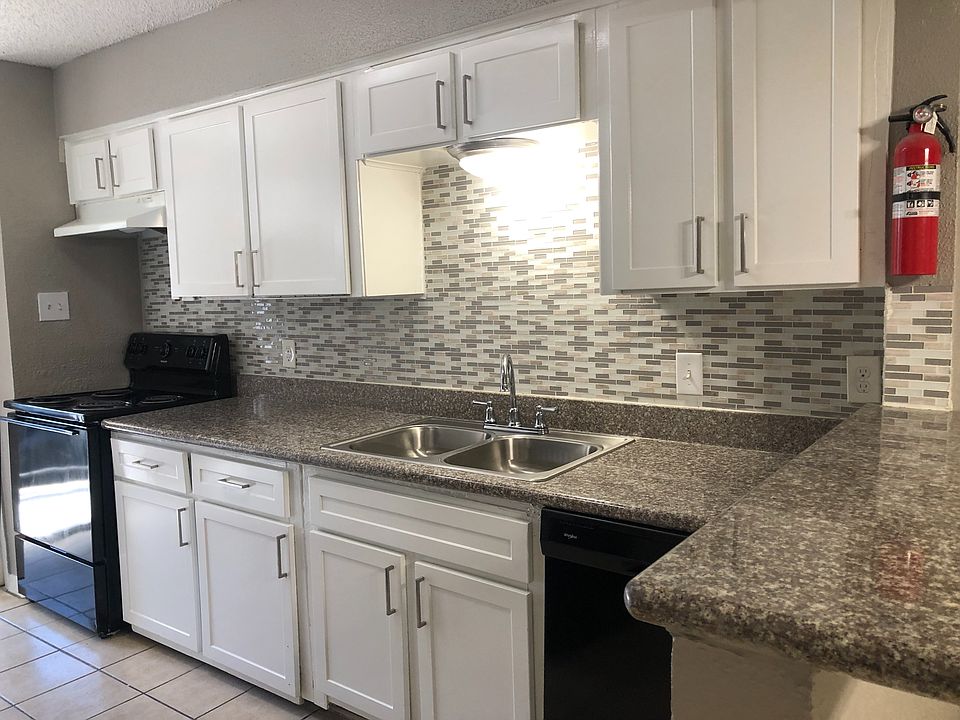 Kitchen with granite countertops, tile backsplash, shaker cabinets, and cabinet hardware