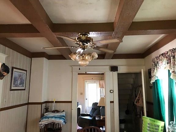 View from kitchen through Dining Room to Living Room.  Note the beamed ceiling and the ceiling fan.