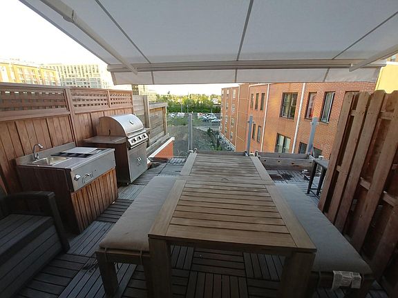 Deck with motorized awning extended. Great for spring/summer lounging. Firepit can go on top of the table. Views of Statue of Liberty!