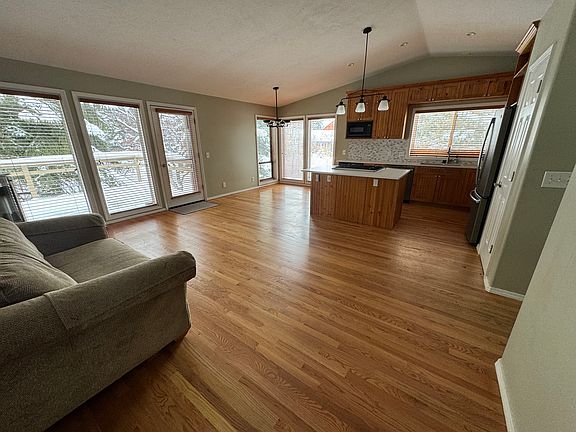 Living area upstairs with kitchen and counter seating, with deck access