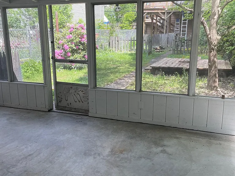 covered back porch in the back that leads to fenced in yard