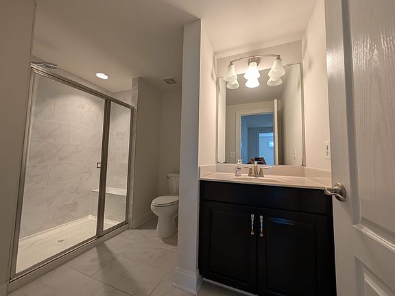 Whole Bathroom view include shower, commode and sink.