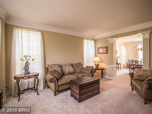 Living room with decorative moldings, bay window