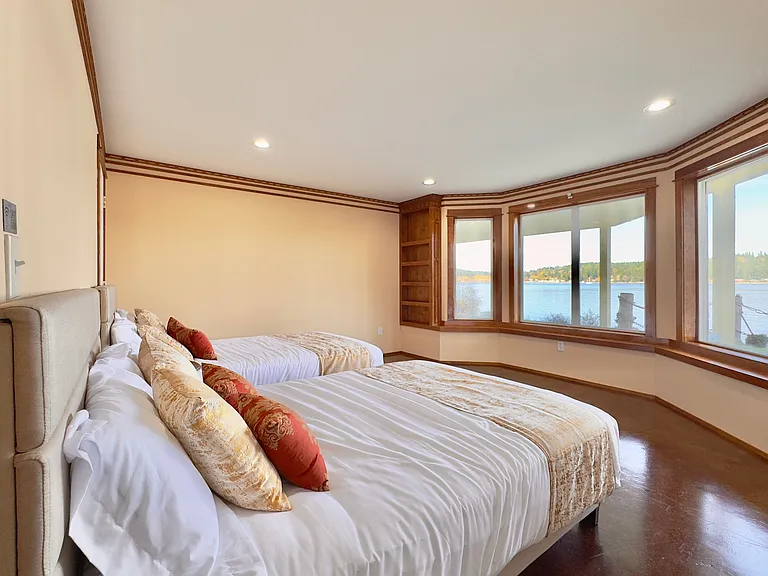 Spacious bedroom with two full beds and panoramic waterfront vistas