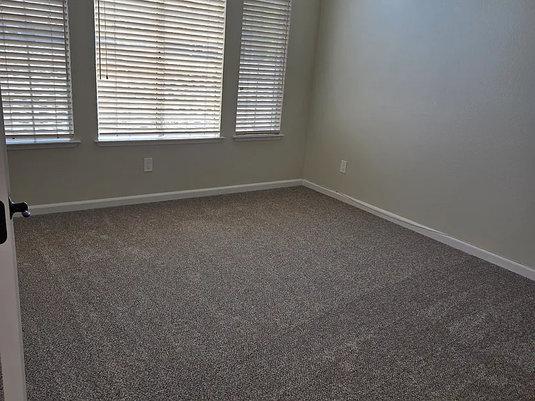Spacious primary suite with soaring vaulted ceilings and dramatic arched window that fills the room with natural light.