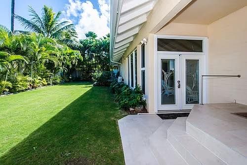 Living room French doors off private tropical garden and gate that leads to the beach