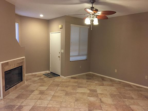 Living room with fireplace, ceiling fan, and entry. 949-422-0612