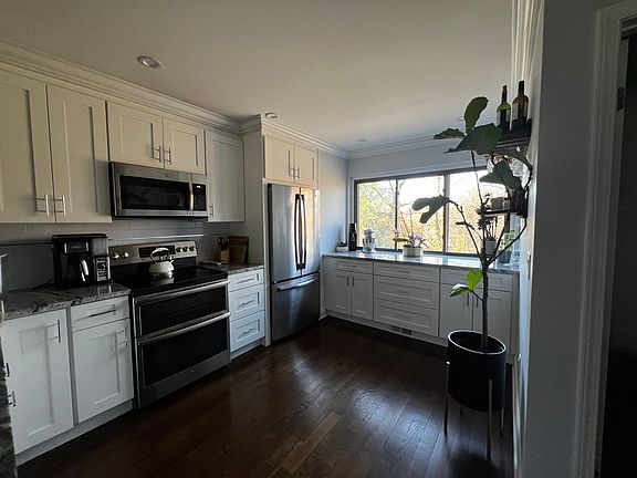 Kitchen with 2 section fridge, pull out freezer drawer and ice maker. Hanging shelves for glass and bar.