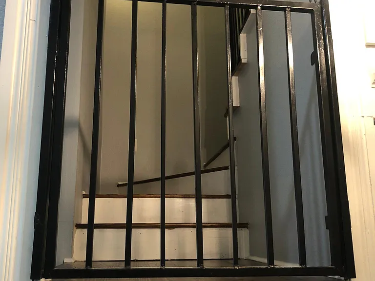 Hinged wrought iron stairway railing conveniently flips down to easily move items to bedroom #3 upstairs.
