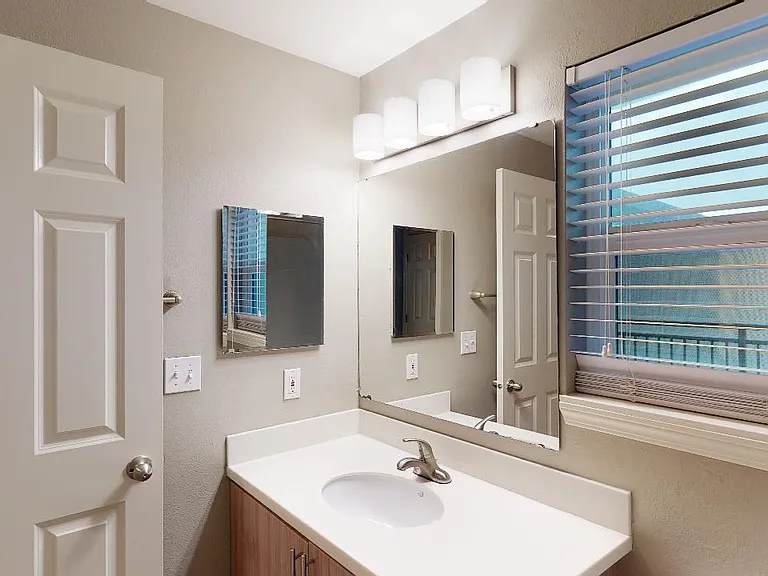 Apartment bathroom with wood-style flooring.