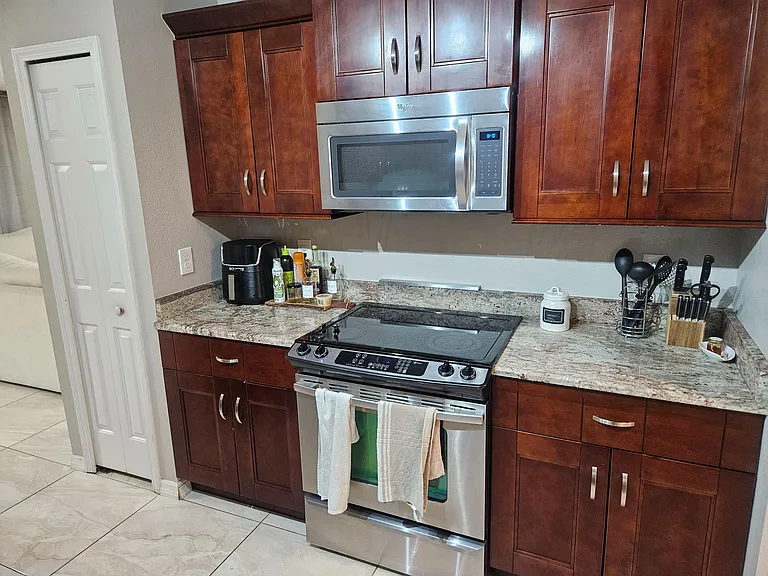 Well-appointed kitchen with ample wood cabinetry, granite counters, and stainless steel range and built-in microwave.