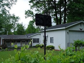 Fenced yard with wooden walkways all around the home, many flower plantings and grape vines for the anyone needing a hobby.