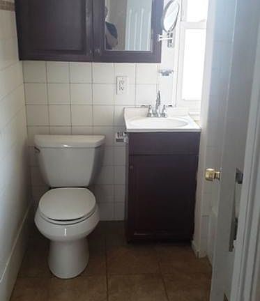 Bathroom has tile floor and tiled walls