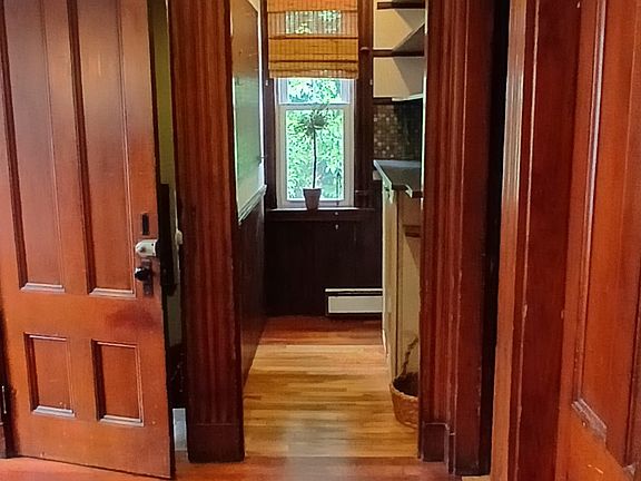View from dining area into kitchen , highlighting natural woodwork & Cherry floors.