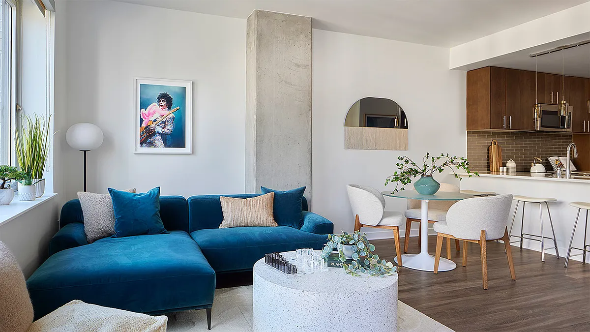 Apartment kitchen with stainless steel appliances, dining and living room with wood-style flooring. - Griffis Platform Union Station
