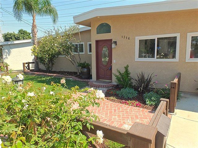 Beautiful curb appeal with professional landscaping and used brick entry way