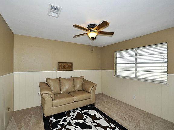 This is a picture of the study. The study has paneled walls with two-tone colors. The ceiling fan is a recent addition as are the faux wood blinds. This room could easily be turned into a 4th bedroom if needed.