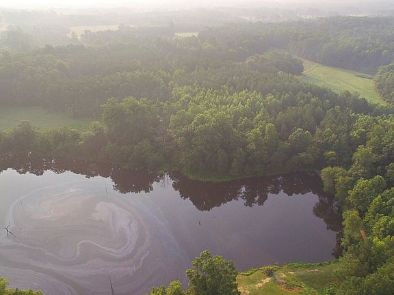 Aerial looking at the property from the backside of the lake showing more than 670 feet of water frontage