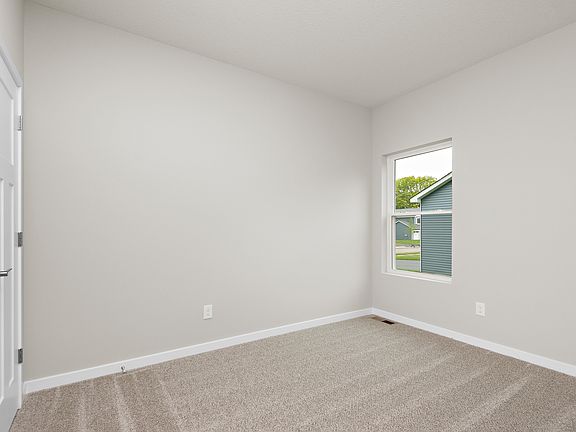 The master bedroom is spacious with carpet.