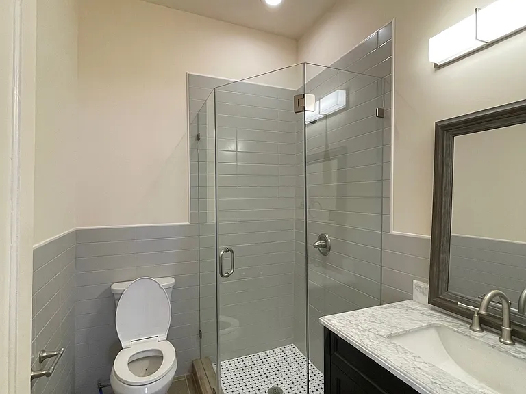 bathroom with shower and marble top vanity