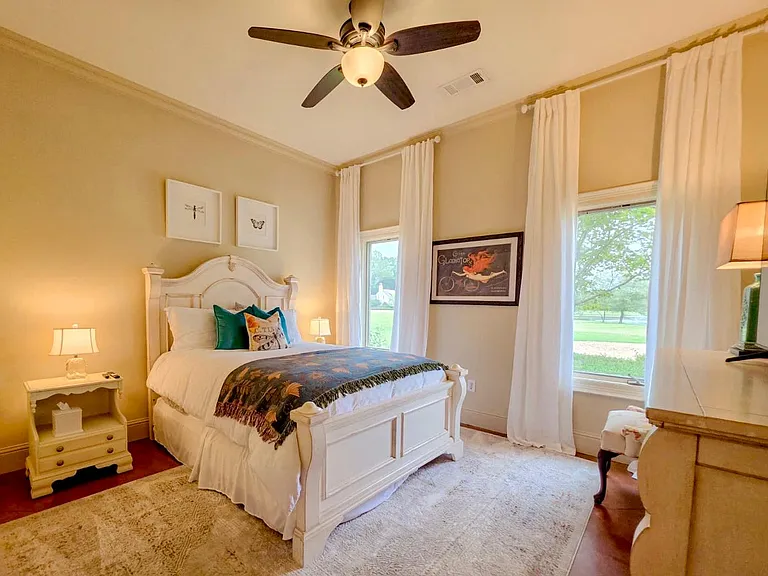 Second ensuite bedroom on main level. Views of the pond. Linen curtains