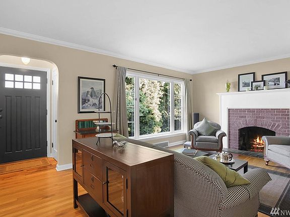 Arched entry opens into the living room which features a custom, brick fireplace surround and mantel. Cove molding finishes the ceilings and solid oak hardwood floors flow throughout the house.