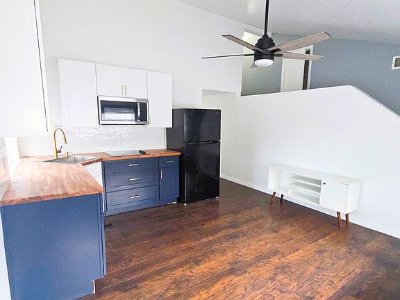 Spacious living area with a stylish ceiling fan and elegant coffee table.