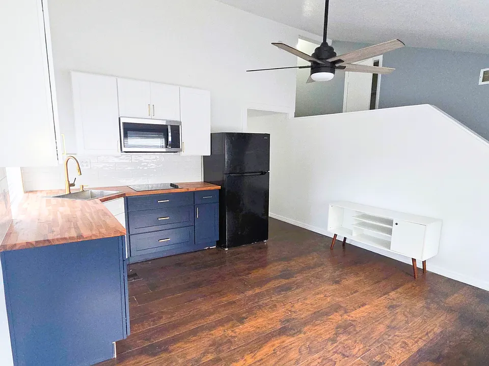 Spacious living area with a stylish ceiling fan and elegant coffee table.