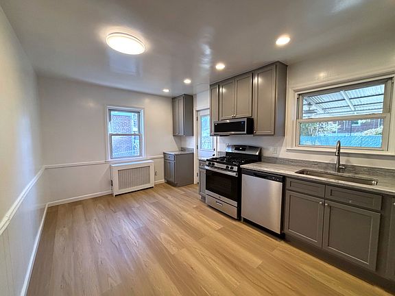Completely renovated kitchen. New floor, cabinetry, and stainless steel appliances. Door to backyard.
