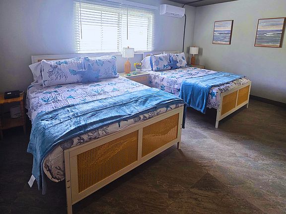 Spacious comfort room with 2 queen beds and bedside lamps