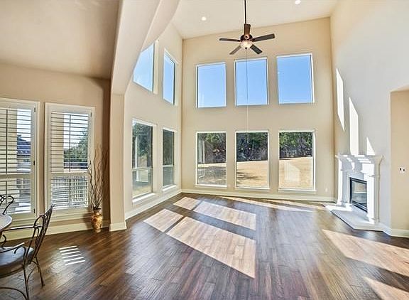 Spacious Taylor Morrison plan with grand two-story living/foyer, stunning hardwood floors, multiple big windows, plantation shutters throughout with motorized shades in living.