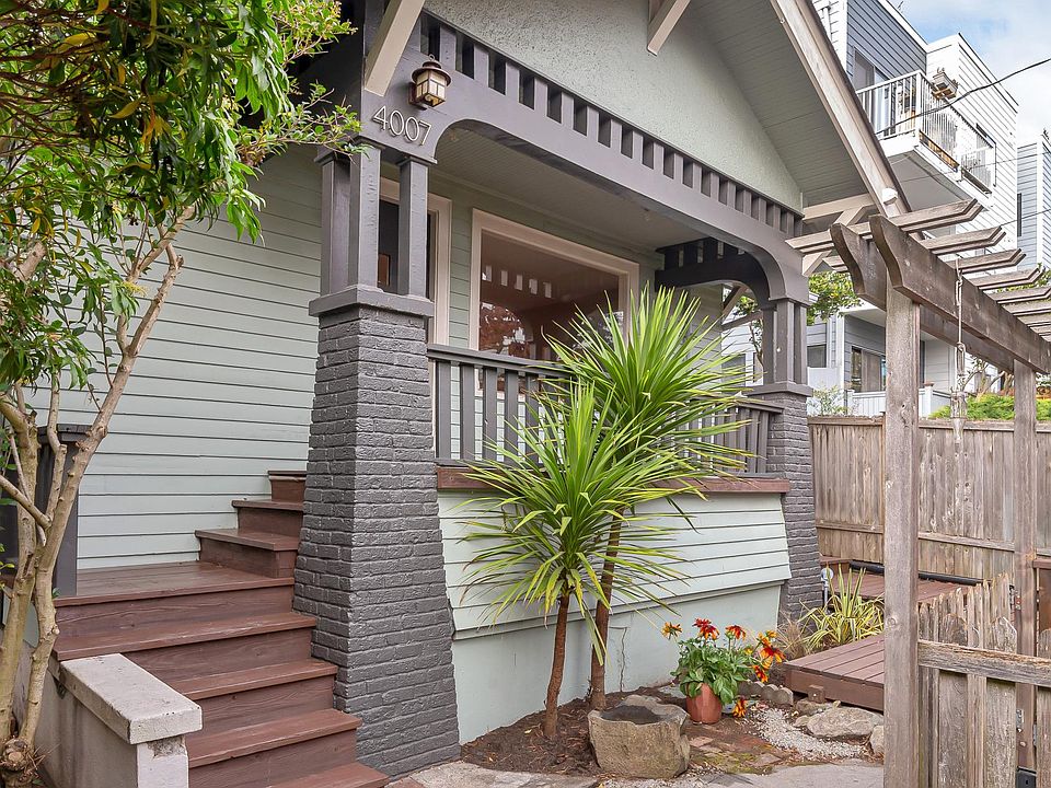 Traditional Bungalow architecture with porch that spans home and reflections of porch facade echoed in front window.