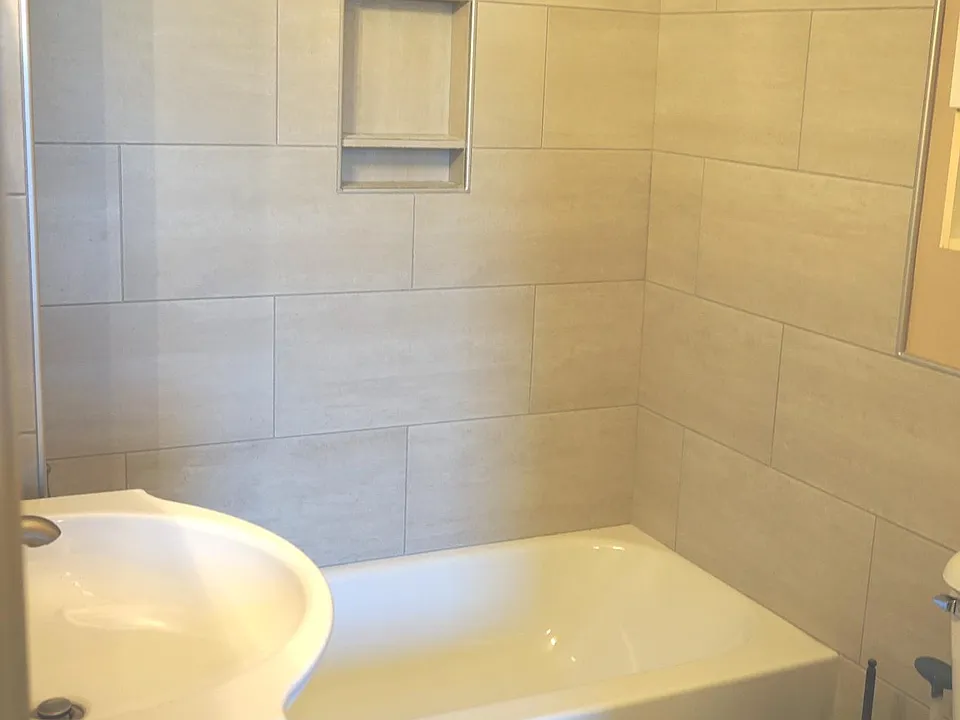 Brand new remodeled bathroom with tiled shower and new vanity.