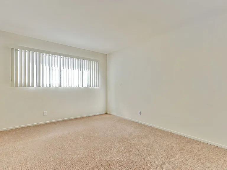 Bedroom with carpeting, vertical blinds on the window