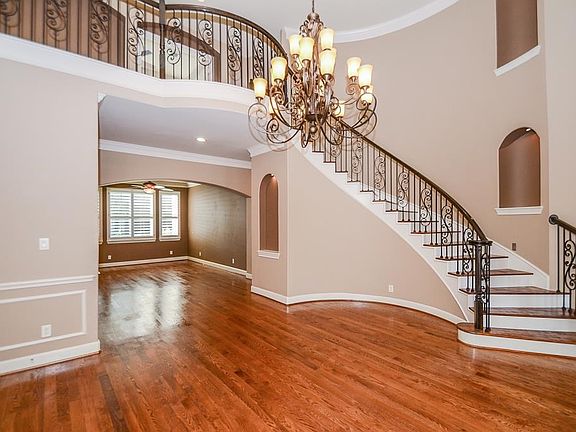 Enter to a grand stair case and formal dining room.