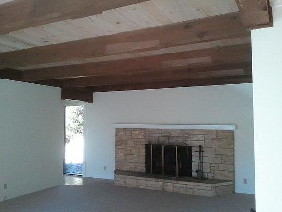 Large stone fireplace and carved beams in Living Room.