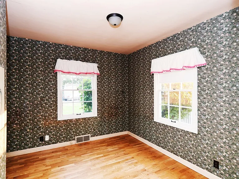 Unit B bedroom on ground floor with windows facing backyard and south side of home.