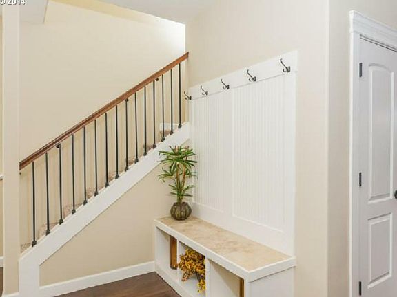 Entry with travertine tile built-in bench and coat rack