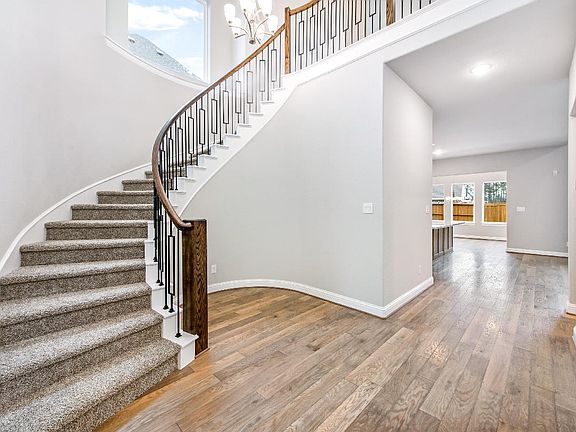 Foyer with curved staircase and wood flooring